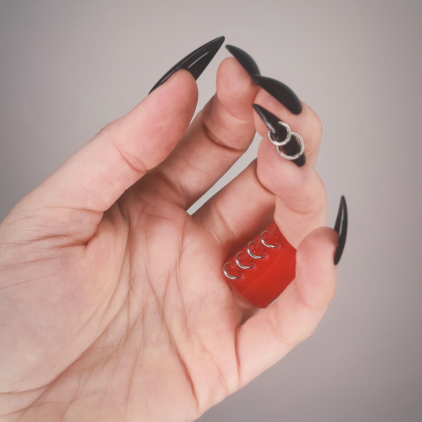 Underside of gothic red PVC ring, with a row of jump rings.
