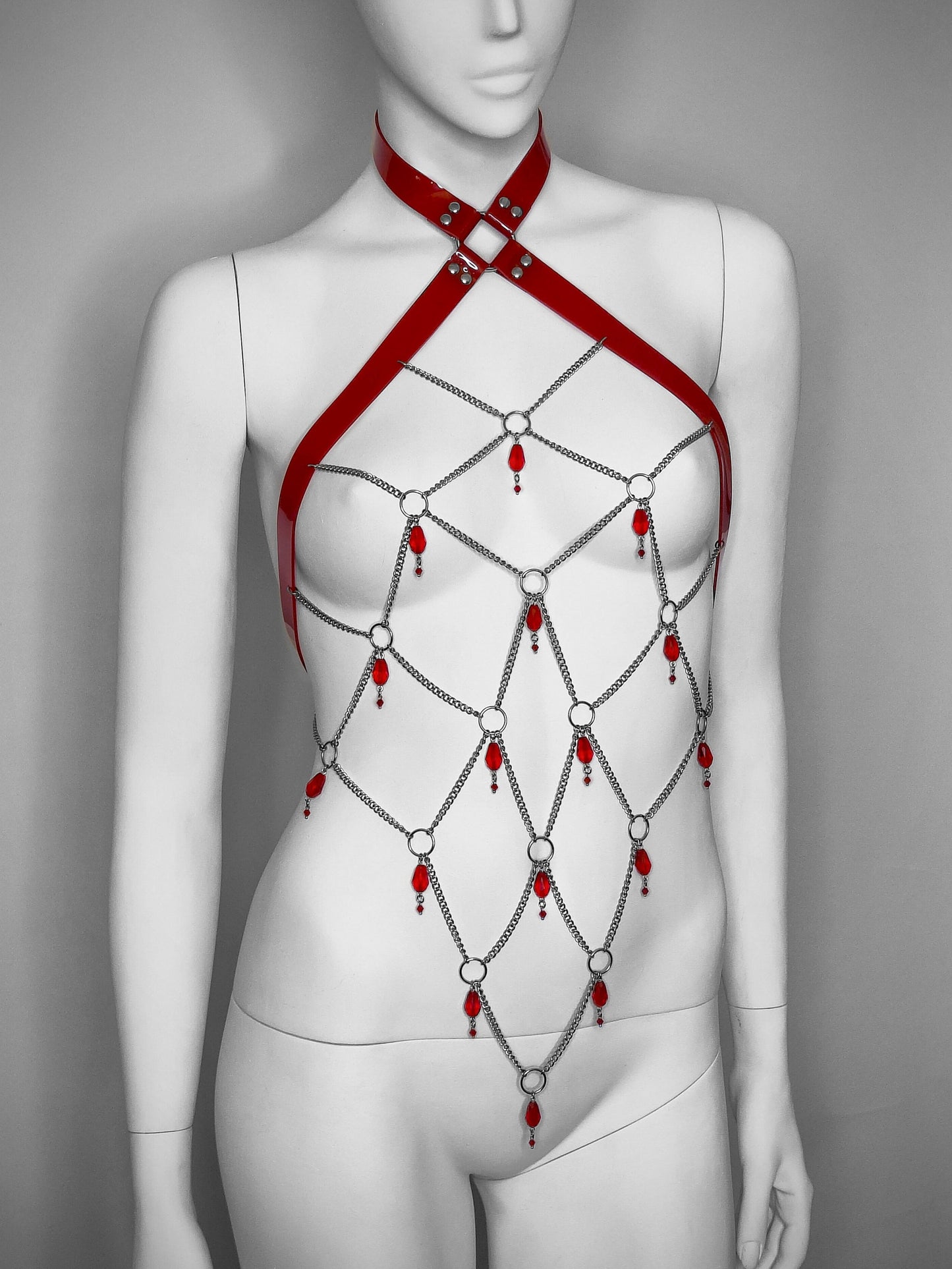 Red gothic PVC body harness with a network of stainless steel chain and red glass beads.