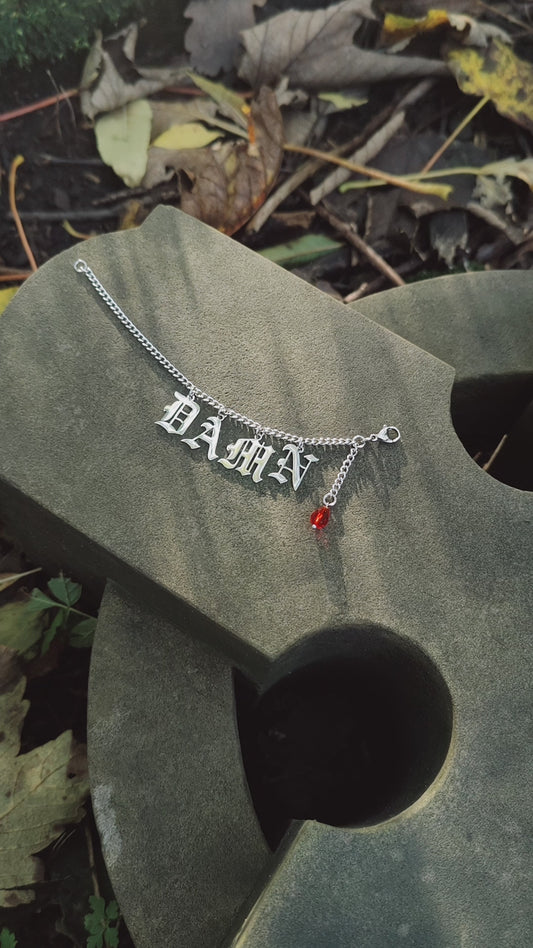 Nose to ear chain with Gothic letter charms and blood droplet earring.