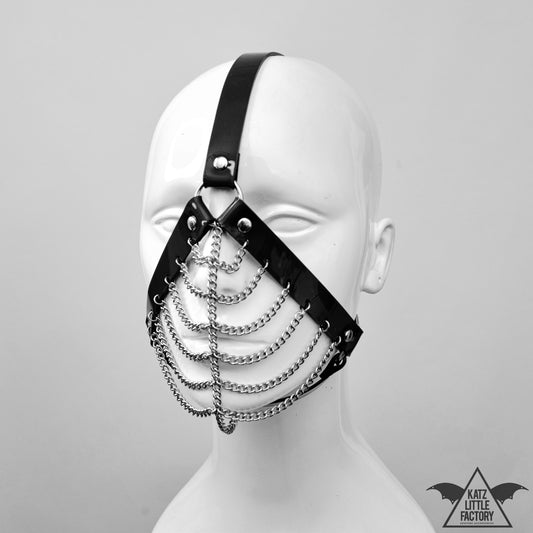 Profile of a gothic black PVC muzzle head harness with stainless steel chains over the mouth and nose.