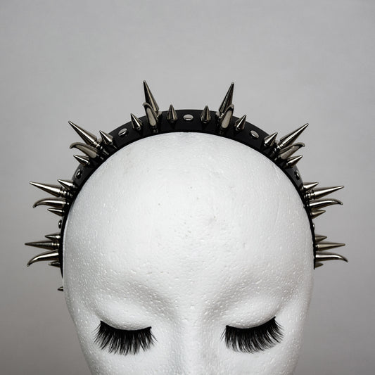 Close-up of gothic black PVC headband adorned with various spikes and studs.