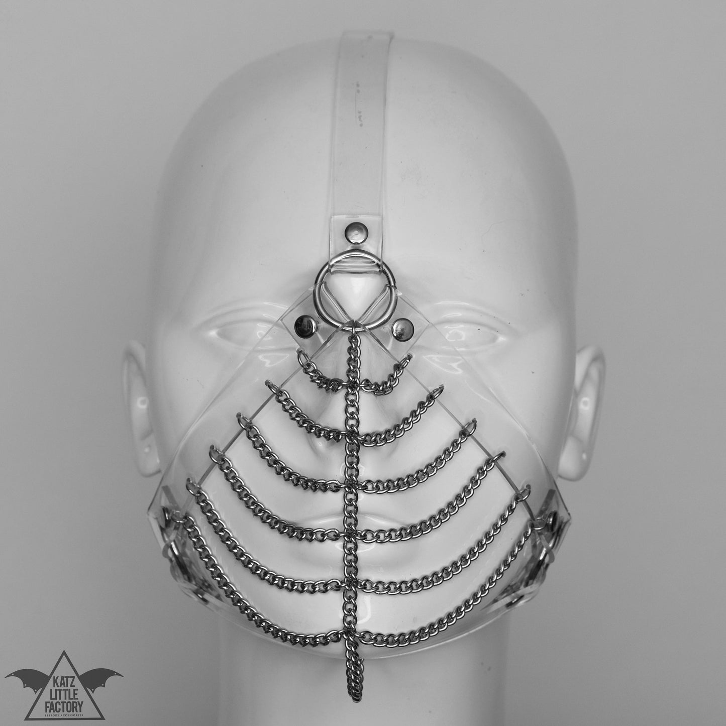 Gothic clear PVC muzzle head harness with stainless steel chains over the mouth and nose.