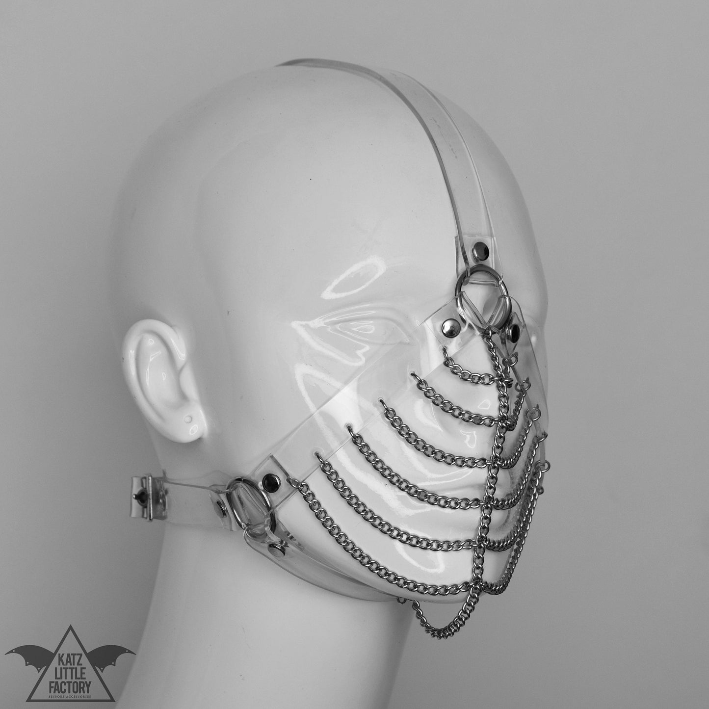 Profile of a gothic clear PVC muzzle head harness with stainless steel chains over the mouth and nose.