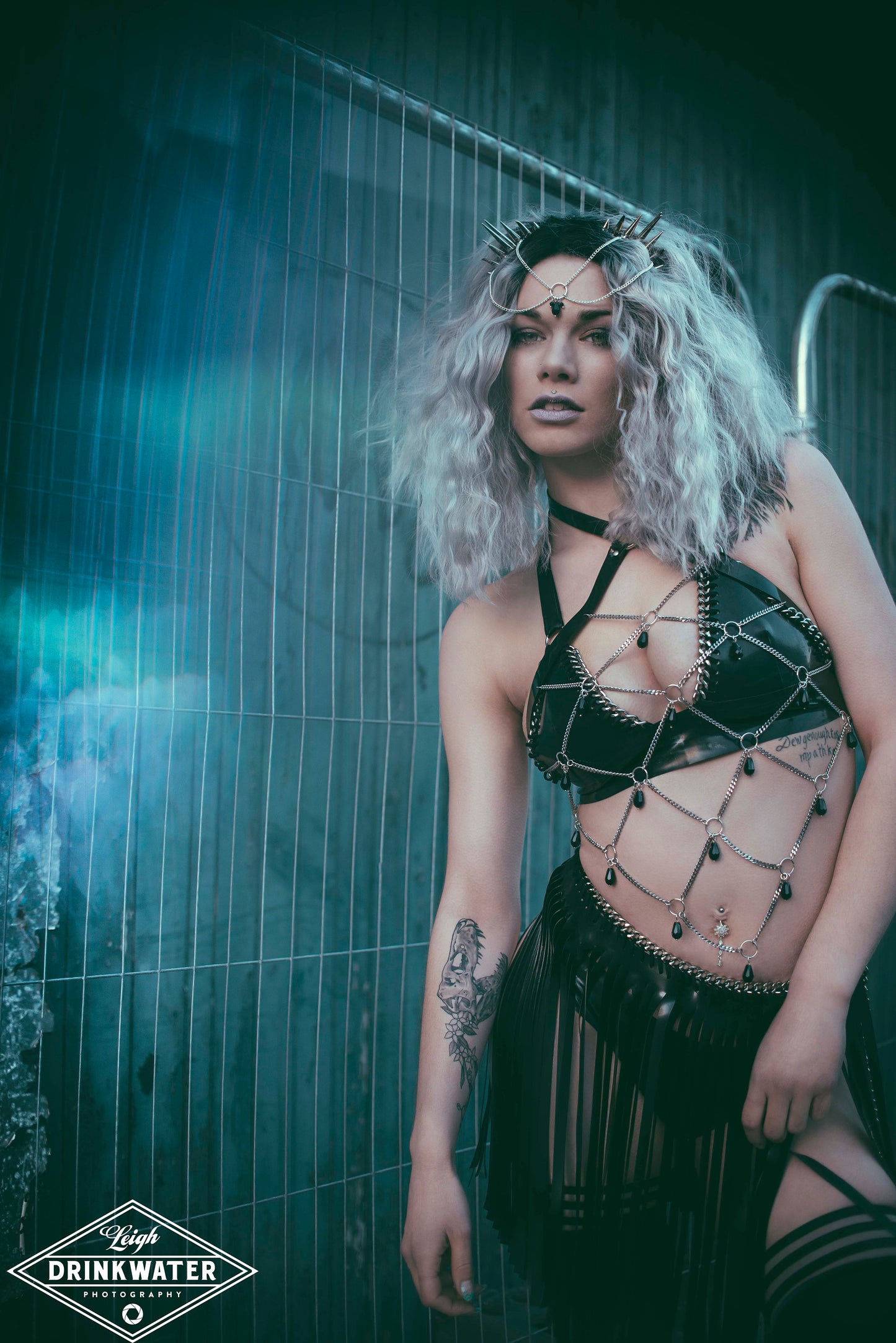 Model wearing black gothic PVC body harness with a network of stainless steel chain and black glass beads.