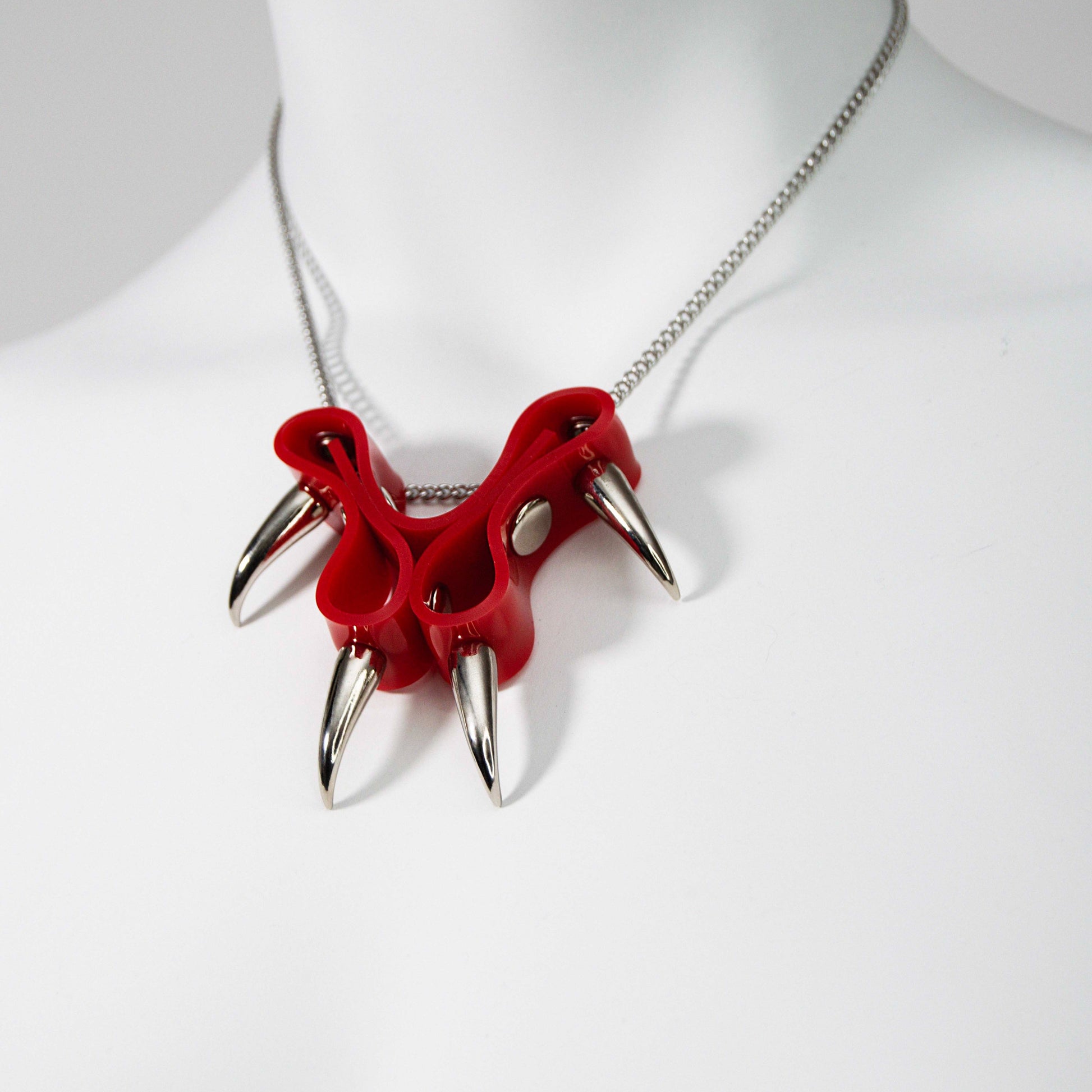 KatzLittleFactory's original CLAWZ necklace showcases a striking combination of red PVC and silver spikes on a chain.