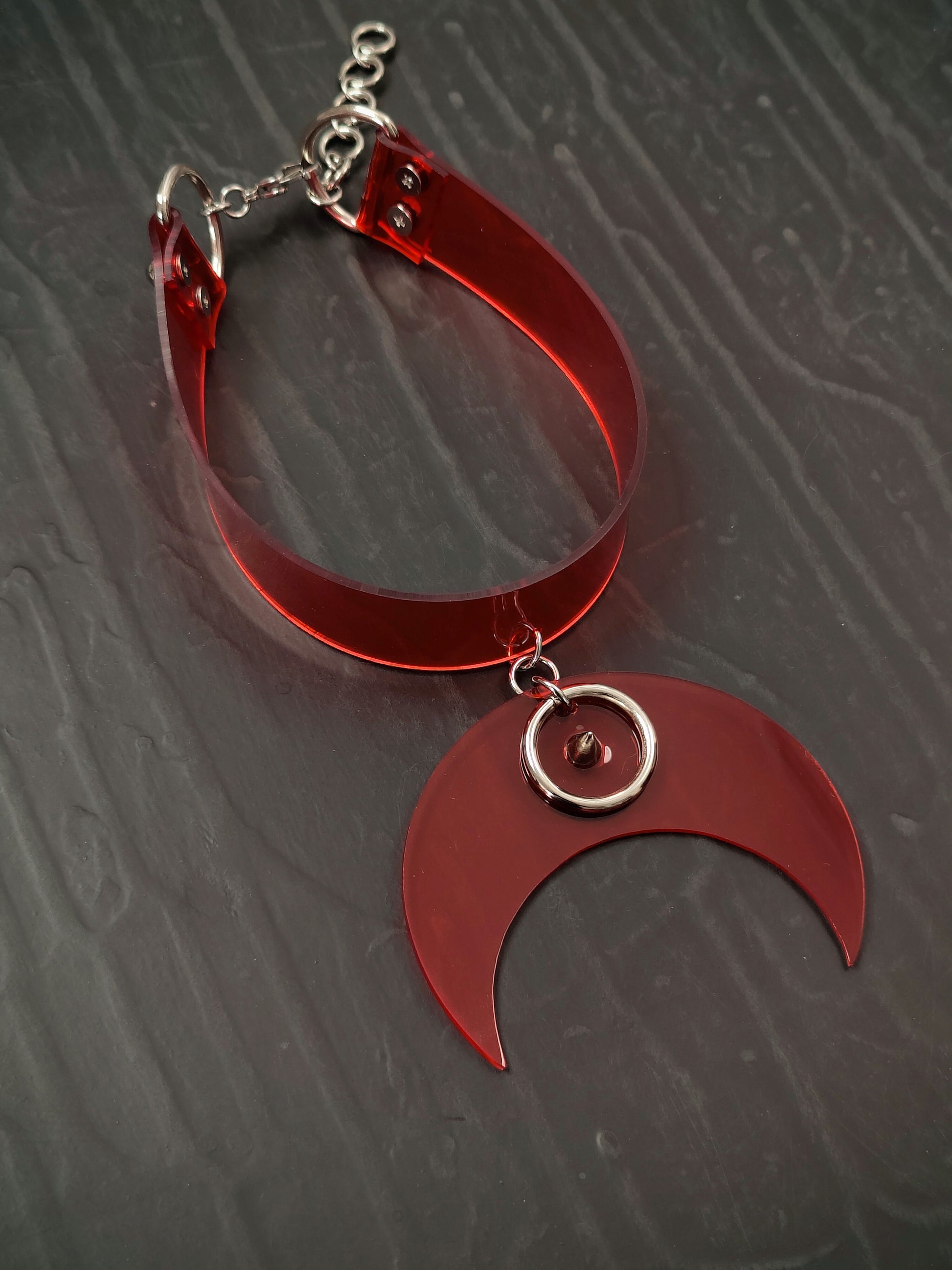 Translucent red vinyl collar with crescent pendant.