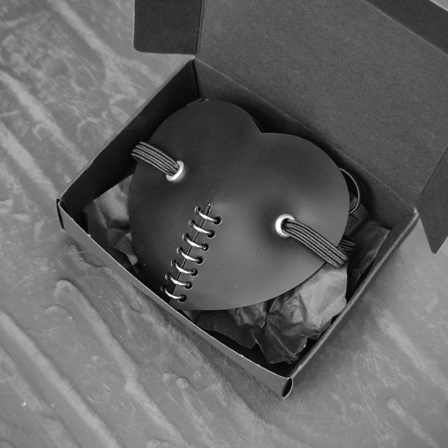 Black heart shape costume eye patch in a gift box.
