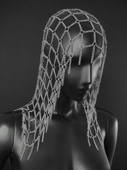 A silver chain fantasy inspired headpiece displayed on a black mannequin head and shoulders against a dark gray studio background.