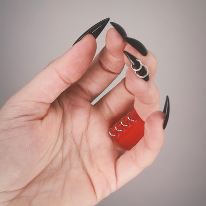 Underside of gothic red PVC ring, with a row of jump rings.