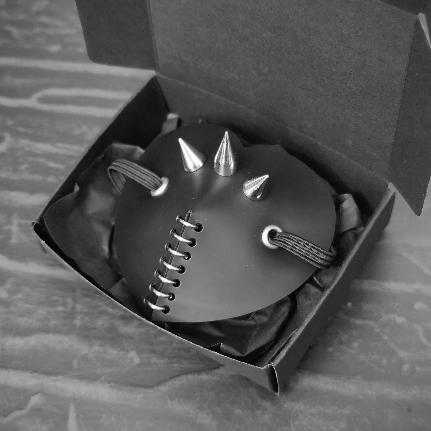 Black heart shape costume eye patch with spike, rings and studs decoration.
