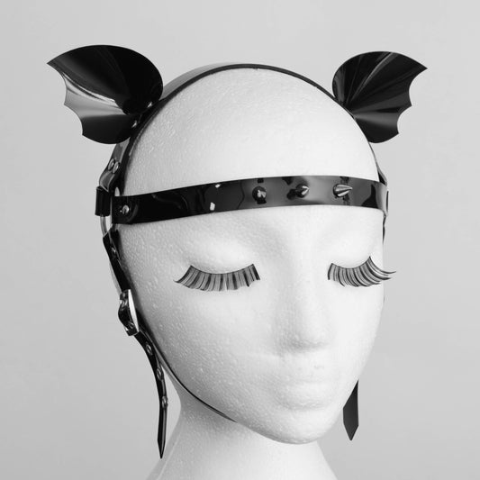 Black PVC studded headband with bat-like wings displayed on a mannequin head, set against a plain background. Ideal for goth or alternative fashion enthusiasts.
