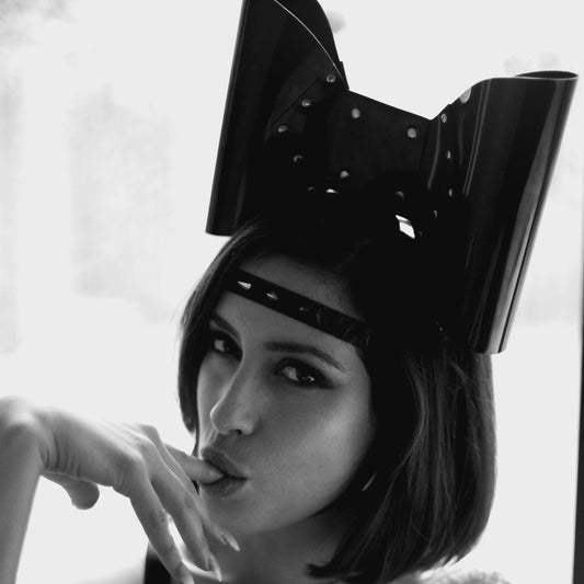 PVC headband with an oversized bow, studs, and a spiked strap across the forehead.